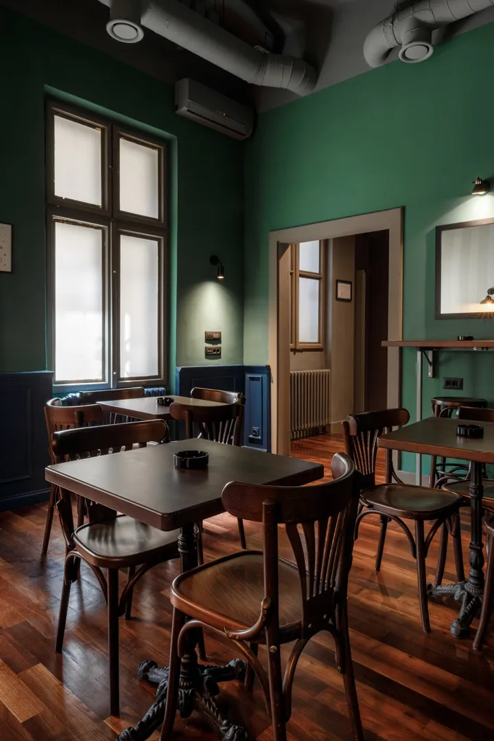 Sala paba Badger & Mug sa zelenim zidovima i drvenim stolovima